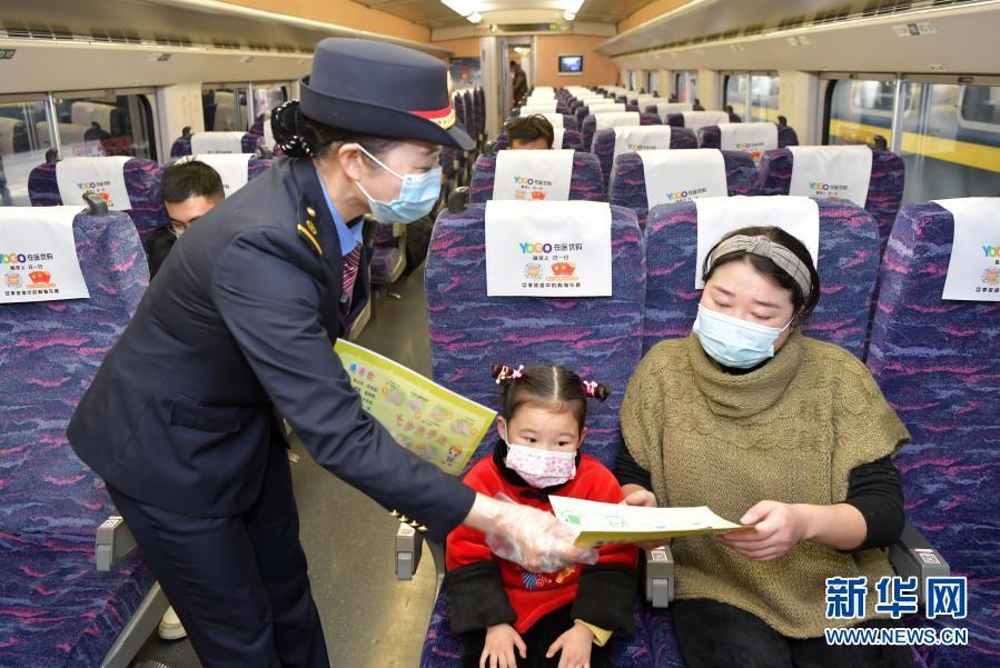 1月28日，在南昌发往婺源的D6264次列车上，乘务员向旅客分发防疫宣传手册。新华社记者 彭昭之 摄