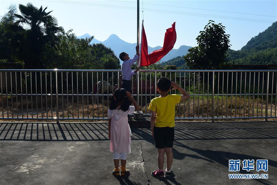 9月7日，在霍山县磨子潭镇金岩教学点，项发权带着两个孩子升国旗。新华社记者 黄博涵 摄